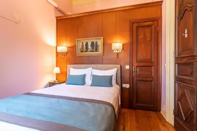 a bedroom with a large bed with blue pillows at Büyükada Anastasia Meziki History Mansion in Buyukada