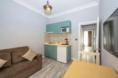 a living room with a couch and a kitchen at Cirrus Suites in Istanbul