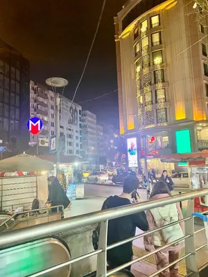 a group of people walking down a street at night at White Suites Hotel İstanbul in Istanbul
