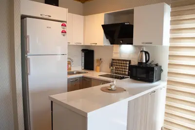 a kitchen with white cabinets and a white refrigerator at King Panorama Suite HI9 in Esenyurt