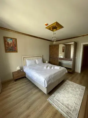 a bedroom with a large white bed and a mirror at King Panorama Suite HI9 in Esenyurt