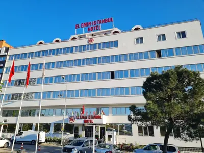 a large white building with cars parked in a parking lot at El Emin İstanbul Hotel in Istanbul