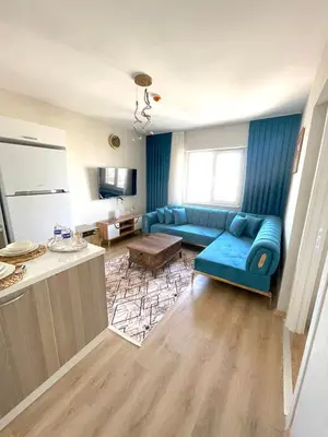 a living room with a blue couch and a kitchen at Two Bedroom King Suite BH46 in Esenyurt