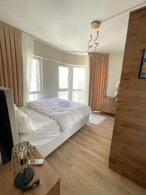 a bedroom with a white bed and a table and window at Two Bedroom King Suite BH46 in Esenyurt