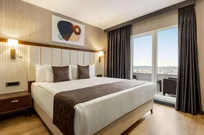 a hotel room with a bed and a large window at Trademark Collection By Wyndham Operla İstanbul Airport Hotels & Spa in Arnavutköy