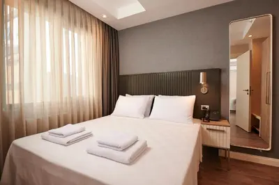 a bedroom with a large white bed with towels on it at Livinton İstanbul Ataşehir in Istanbul