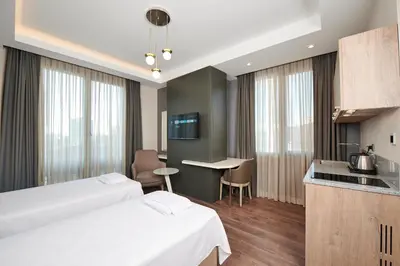 a hotel room with two beds and a kitchen at Livinton İstanbul Ataşehir in Istanbul
