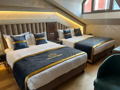 a hotel room with two beds and a chair at MANORS HOTEL in Istanbul