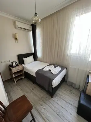 a bedroom with a bed and a table and a window at Oren Hotel in Istanbul