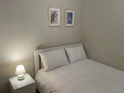 a bedroom with a white bed with a lamp and two pictures at Apt w/ Balcony in center,5 mn walk to Istiklal in Istanbul
