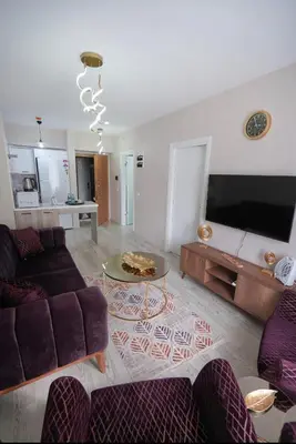 a living room with a couch and a tv at Luxe Suite HA8 in Esenyurt