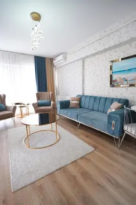 a living room with a blue couch and a table at King Suite OK0 in Esenyurt