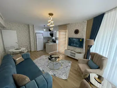 a living room with a blue couch and a table at King Suite OK0 in Esenyurt