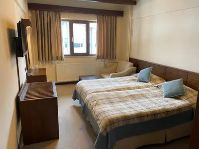 a hotel room with two beds and a television at Beceren Hotel in Bursa