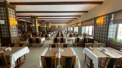 a dining room with tables and chairs and windows at Beceren Hotel in Bursa