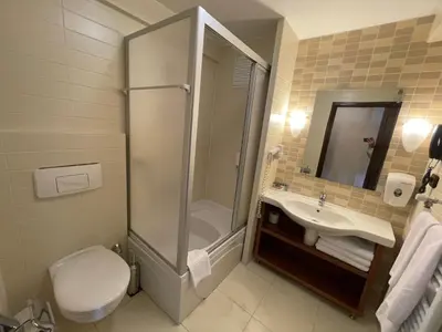 a bathroom with a shower and a toilet and a sink at Beceren Hotel in Bursa