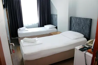 two beds in a hotel room with a phone at biglife hotel in Istanbul