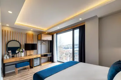 a bedroom with a bed and a desk with a television at Union Hotel Karaköy in Istanbul