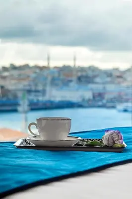 a cup of coffee and a flower on a table at Union Hotel Karaköy in Istanbul