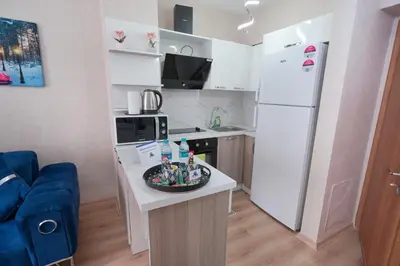 a small kitchen with a white refrigerator and a table at Classic Suite TS33 in Esenyurt