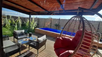 a porch with a swing and a swimming pool at UĞURLUBUNGALOV in Sapanca