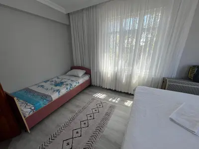 a small bedroom with two beds and a window at Airport See Viem Apartment in Arnavutköy