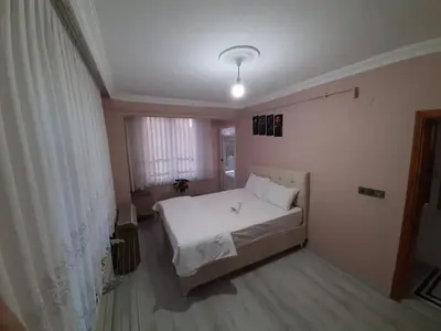 a bedroom with a white bed and a window at Airport See Viem Apartment in Arnavutköy