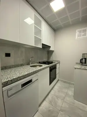 a white kitchen with a sink and a counter top at Whole Apartment at The Heart of Sisli Nisantasi K in Istanbul