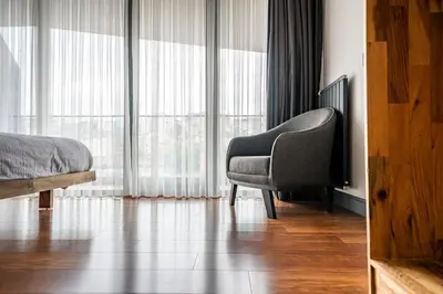 a bedroom with a chair and a large window at Benesta Guest Teori in Istanbul