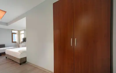 a bedroom with a large wooden cabinet next to a bed at Park Çağlayan Hotel in Istanbul