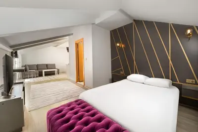 a bedroom with a large bed and a purple couch at Park Çağlayan Hotel in Istanbul