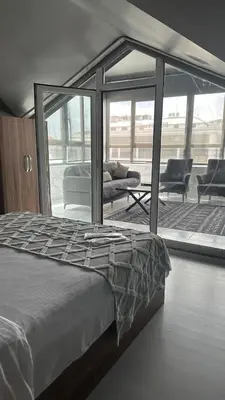 a bedroom with a bed and a patio with chairs at Heraldic Room Hotel in Esenyurt