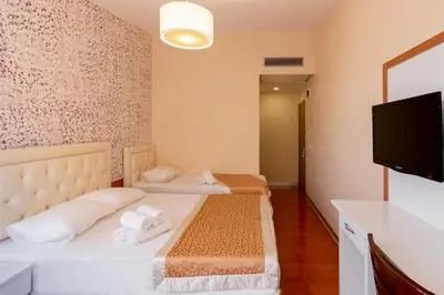 a bedroom with two beds and a flat screen tv at The Center Hotel in Istanbul