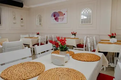 a dining room with white tables and white chairs at My Palace Residance in İçmeler