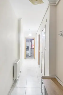 a hallway of a house with white walls and white tile floors at İstanbul'un merkezinde Cevahir AVM karşısı 1+1 yeni ev in Istanbul