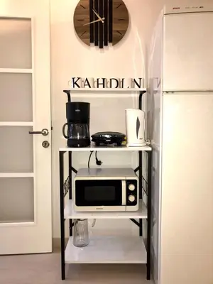 a microwave on a shelf next to a refrigerator at İstanbul'un merkezinde Cevahir AVM karşısı 1+1 yeni ev in Istanbul