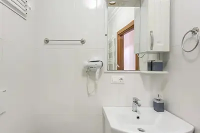 a white bathroom with a sink and a mirror at İstanbul'un merkezinde Cevahir AVM karşısı 1+1 yeni ev in Istanbul