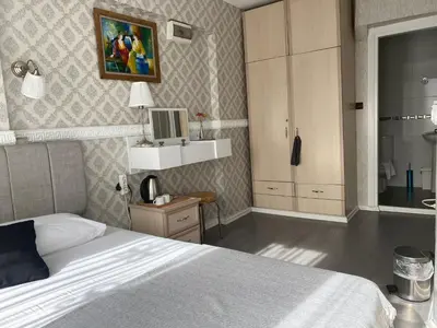 a bedroom with a white bed and a mirror at antik sofia hotel in Istanbul