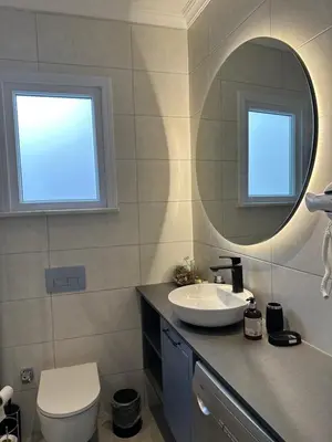 a bathroom with a sink and a mirror and a toilet at Center of city in Beşiktaş 2 plus 1 with 2 Bathroom and 3 Air Conditioner in Istanbul