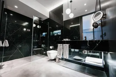 a black bathroom with a toilet and a shower at The Mill Bomonti in Istanbul