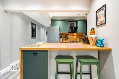 a kitchen with green cabinets and green stools at a counter at sevim suites Nişantaşı in Istanbul