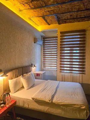 a bedroom with a large bed with a window at Karakoy Port House in Istanbul