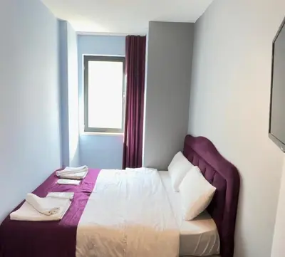 a bed in a small room with a window at Taksim Soushian Hotel in Istanbul