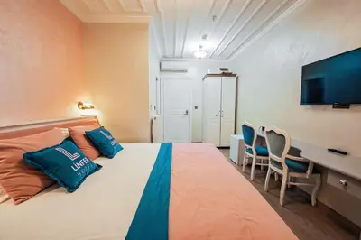 a bedroom with a large bed with a desk and chairs at Linfer Hotel Taksim in Istanbul