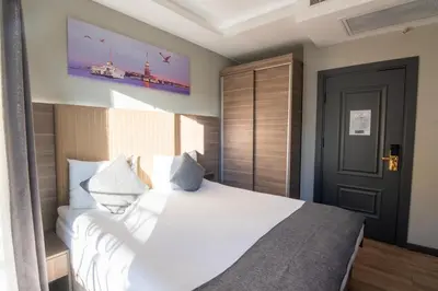 a bedroom with a bed with white sheets and pillows at The Omiya Hotel in Istanbul