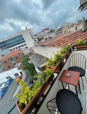 a balcony with plants and chairs on a building at Elegance Aparts Cihangir in Istanbul