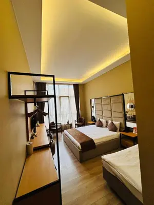 a hotel room with two beds and a desk and a lamp at Berfinn Hotel Ortaköy in Istanbul