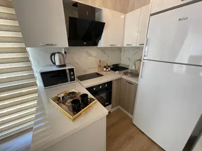 a small kitchen with a refrigerator and a sink at King Suite ZG5 in Esenyurt