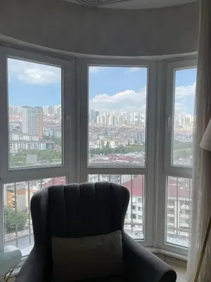a living room with a couch in front of windows at King Suite ZG5 in Esenyurt