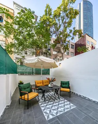 a patio with a table and chairs and an umbrella at Hexa Suites Hotel in Istanbul